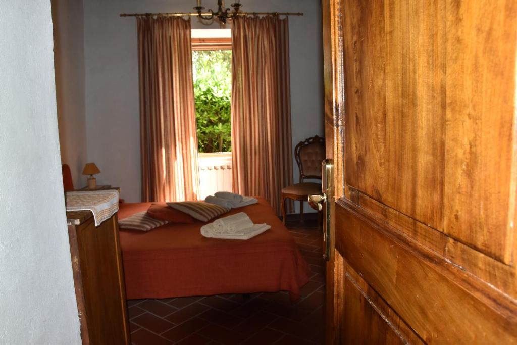 a small bedroom with a bed with a window at Borgo Vecchio in Montalcino