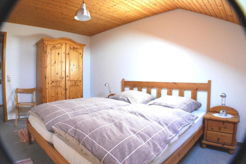 ein Schlafzimmer mit einem großen Bett und einer Holzdecke in der Unterkunft Ferienwohnung Hilmes-Walravens in Isny im Allgäu