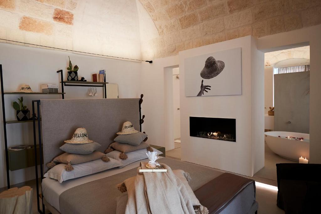 a bedroom with a bed with pillows and a fireplace at Musae Relais & SPA in Polignano a Mare