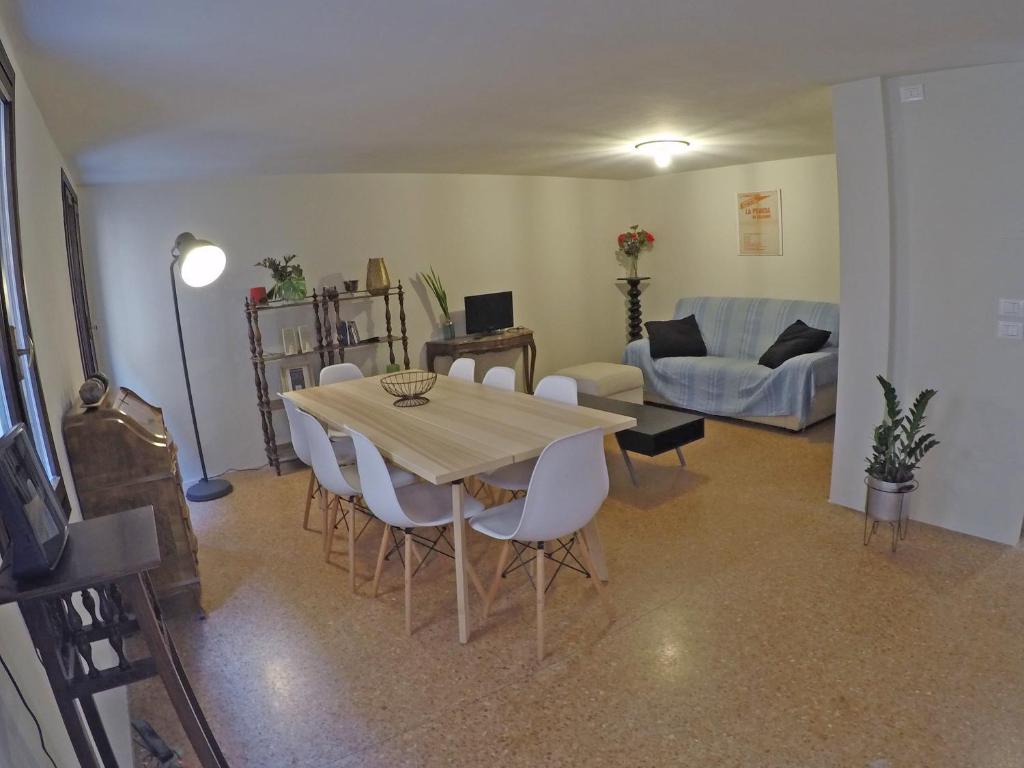 een woonkamer met een tafel en stoelen en een bank bij San Polo Family Apartment in Venetië