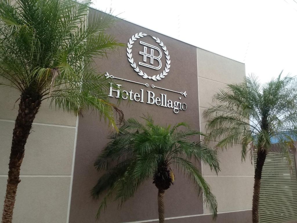 een hotelgebouw met palmbomen ervoor bij Hotel Bellagio in Campo Grande