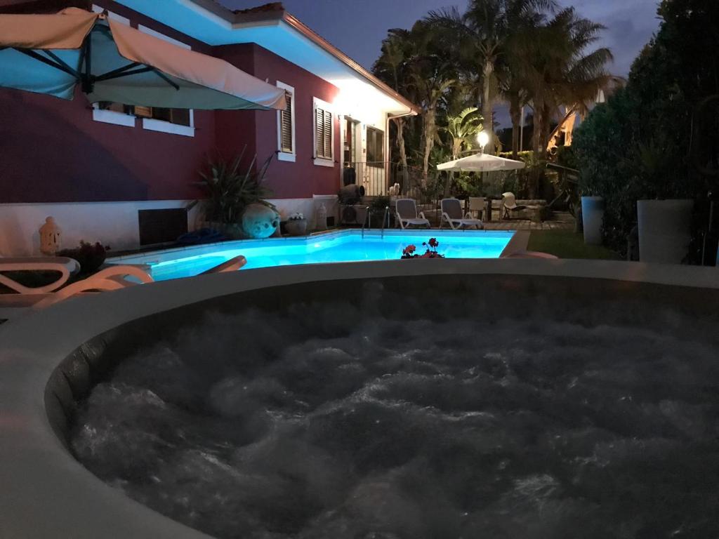 a hot tub in front of a house at night at Villa Margherita in Pozzallo