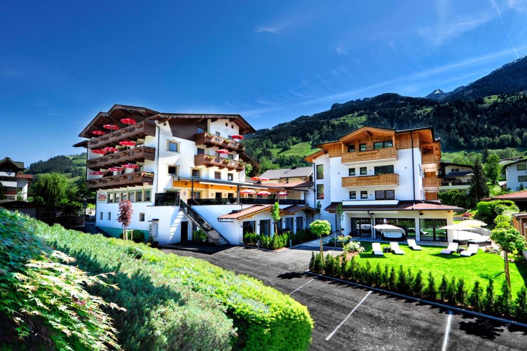 un grupo de edificios en una colina con un patio en Hotel Theresia en Ramsau im Zillertal