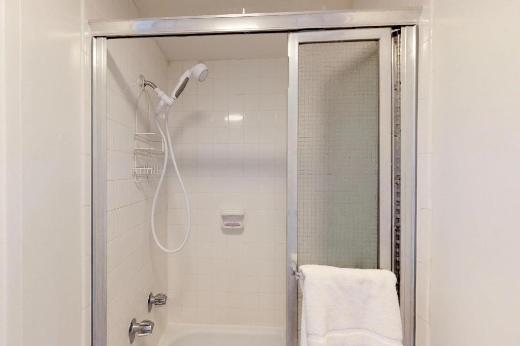 La salle de bains est pourvue d'une douche avec une porte en verre. dans l'établissement Harbor View Plaza #1203, à Honolulu