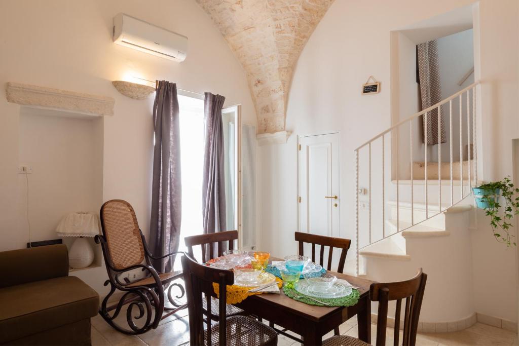 a dining room with a table and chairs and a staircase at Casa Antica Pietra Bianca in Ostuni