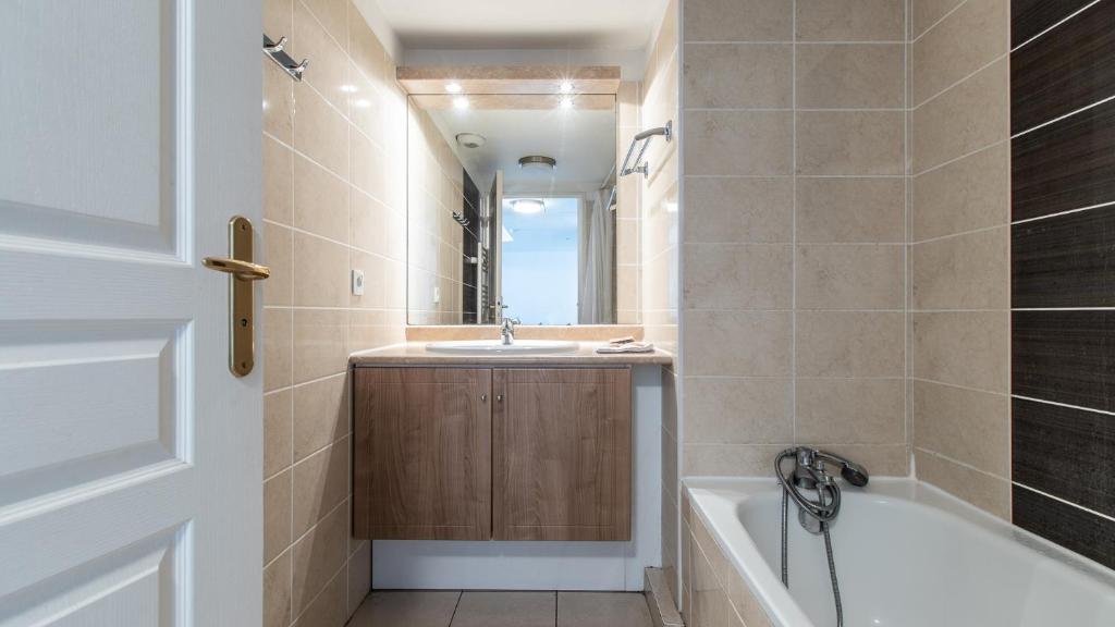 a bathroom with a sink and a bath tub at Vacancéole - Résidence Le Crystal in Cagnes-sur-Mer