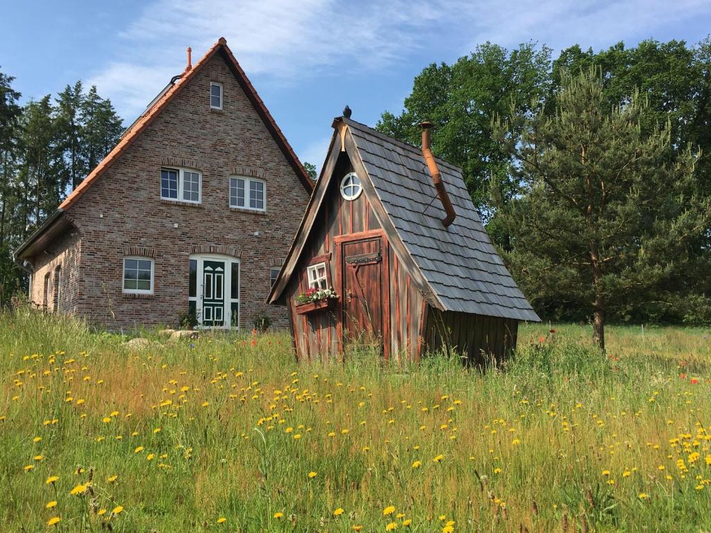 Ein altes Haus auf einem Blumenfeld in der Unterkunft Bispinger Heidezauber - Haus Hartriegel in Bispingen