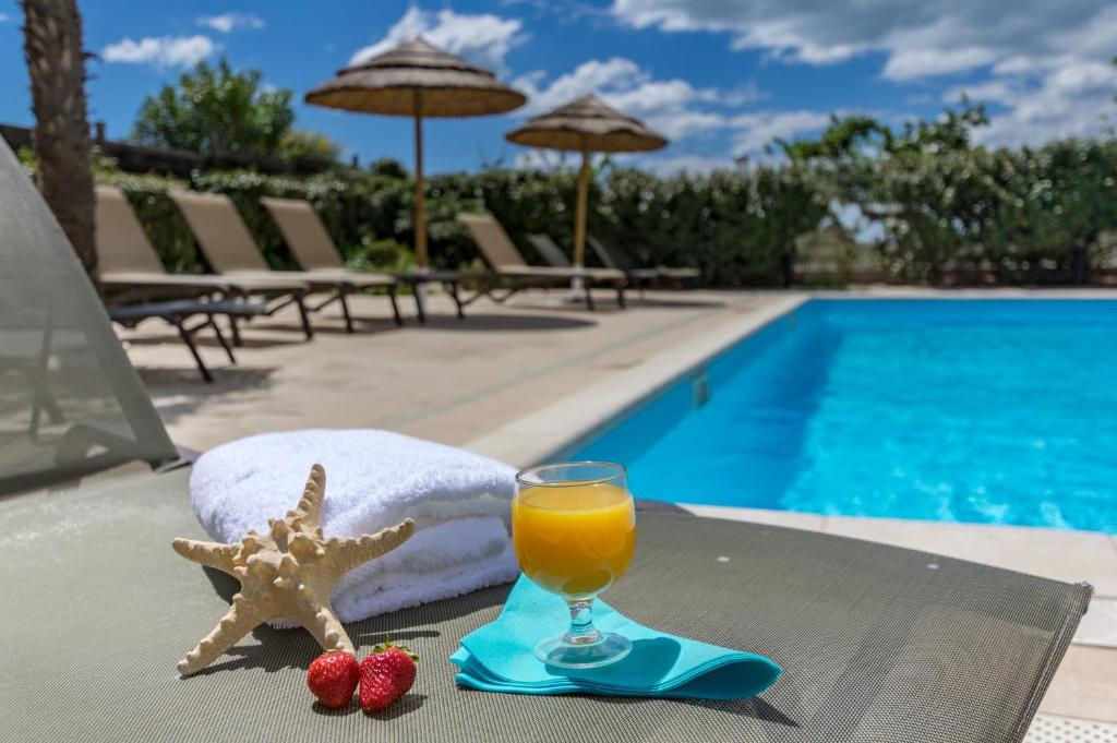 a starfish and a glass of orange juice on a table by a pool at Résidence Thalacap in Cap d'Agde