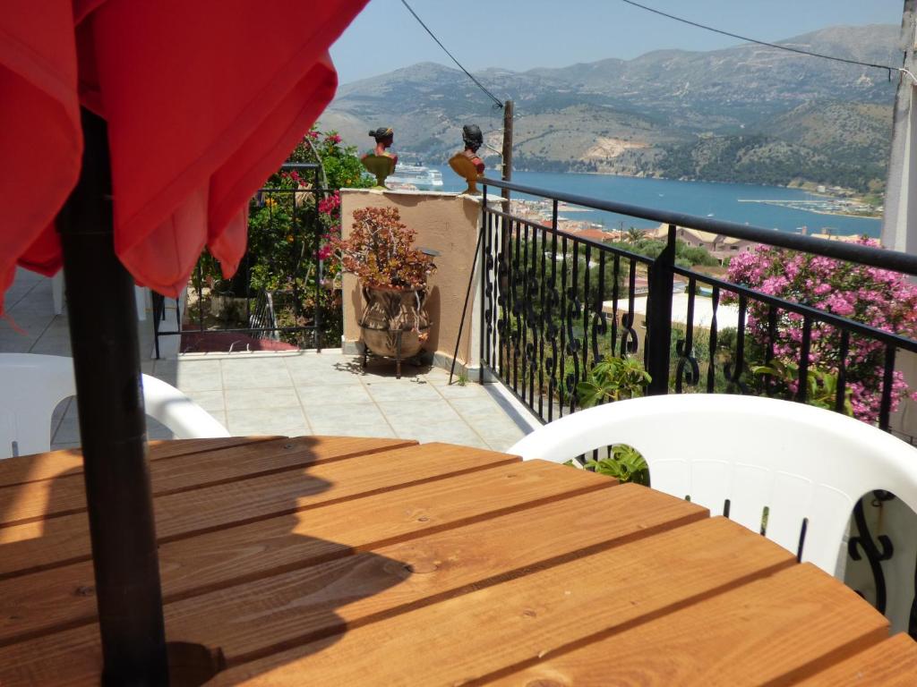 a wooden table and chairs on a balcony with a view at Anna Apartments in Argostoli