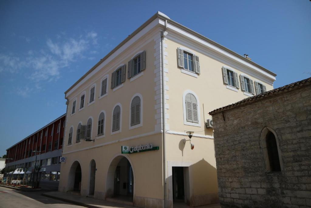 un gran edificio blanco junto a un edificio de ladrillo en APP E.N.A. en Umag