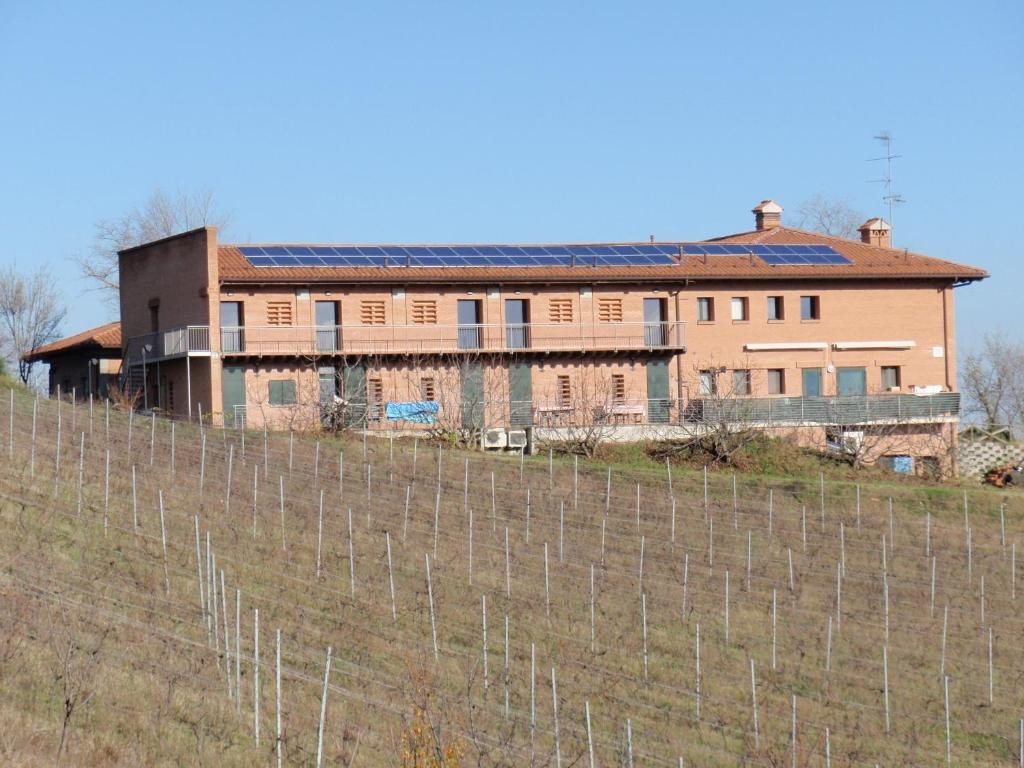 una casa en una colina detrás de una valla en Agriturismo Il Poggiolo, en Pianoro