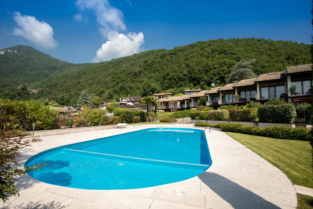 - une piscine dans une cour avec des montagnes en arrière-plan dans l'établissement Garda Hills Residence, à Roe