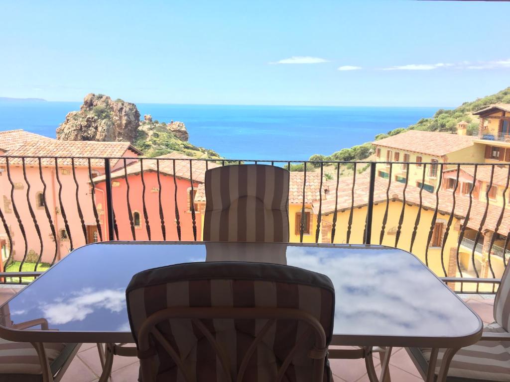 a table on a balcony with a view of the ocean at A WINDOW ON THE SEA in Nebida