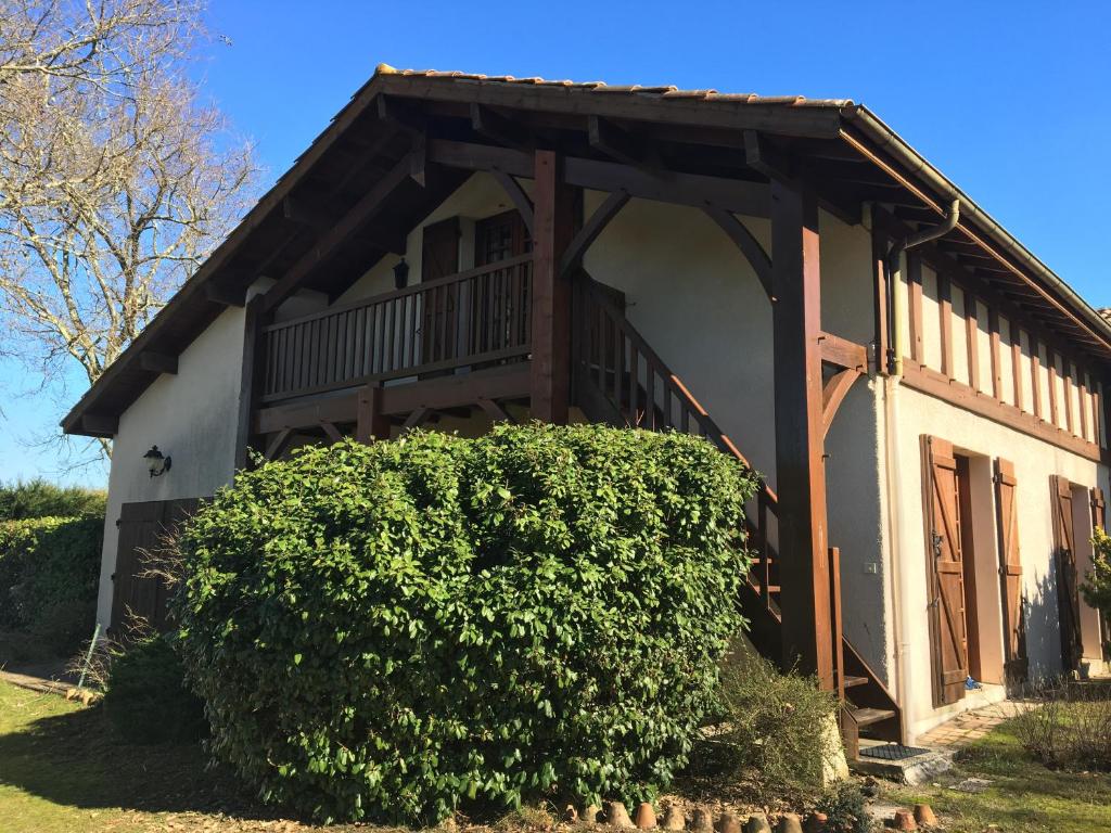 a house with a large bush in front of it at Stemicar dans les Landes in Lesperon