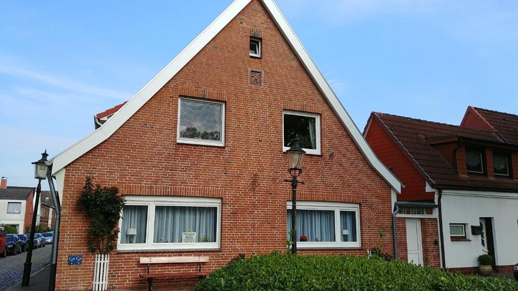a red brick house with a pointed roof at Ferienwohnung Hansen-Jöns in Friedrichstadt