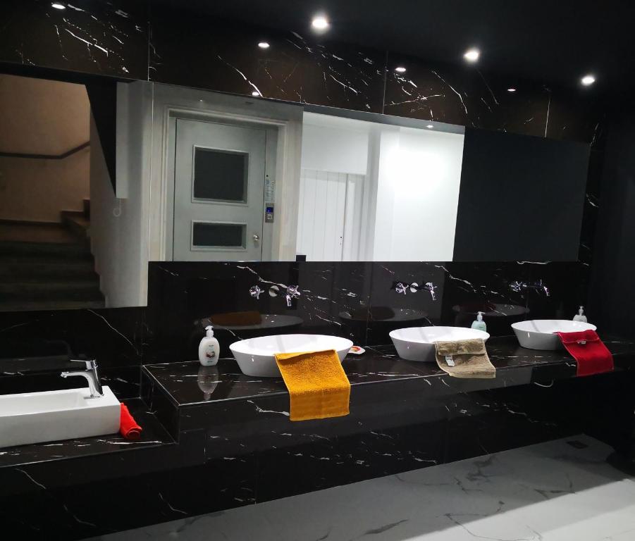 a black bathroom with two sinks and a mirror at Thalia deco City & Beach Hotel in Hersonissos
