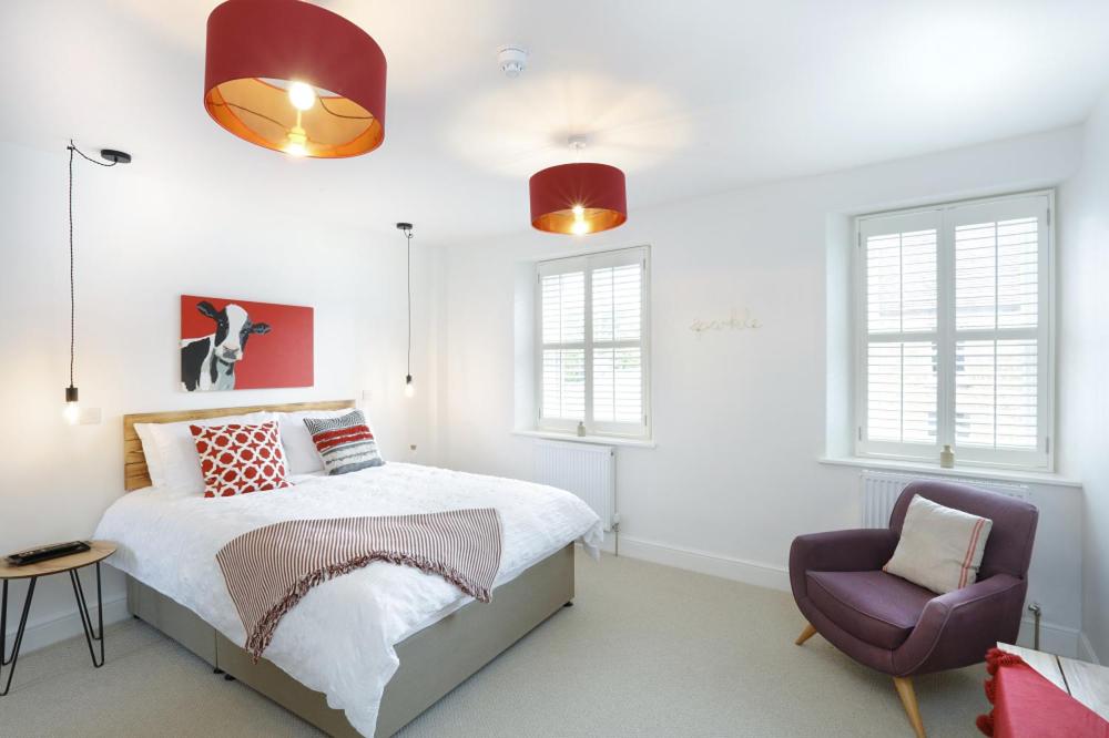 a bedroom with a bed and a chair at Hues - Castle Cary in Castle Cary