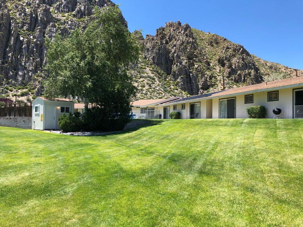 a building with a large yard with a mountain in the background at Meadowcliff Lodge Coleville in Coleville