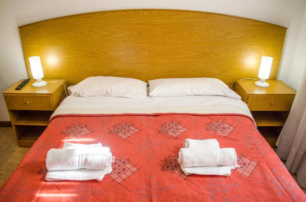 a bedroom with a large bed with towels on it at Complejo Granaderos in Mendoza