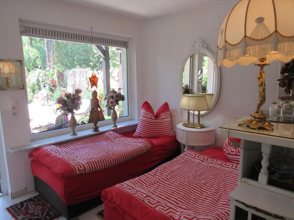 two beds in a room with a window and a mirror at grüne aue in Wilhelmshorst