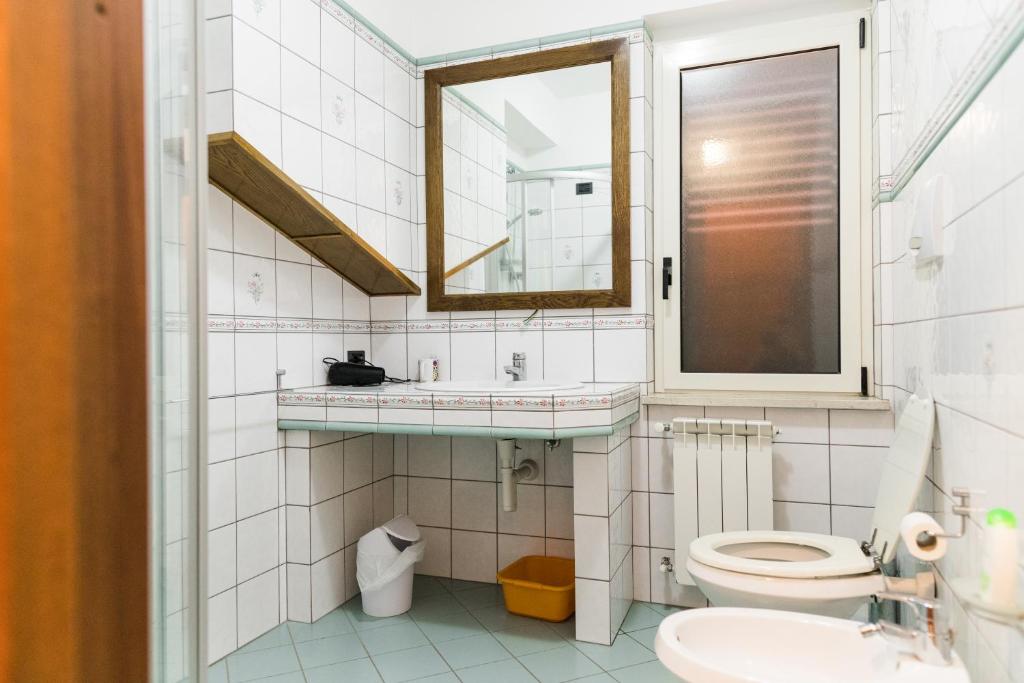 ein Badezimmer mit Toilette, Waschbecken und Spiegel in der Unterkunft Torre Ancinale in Soverato Marina