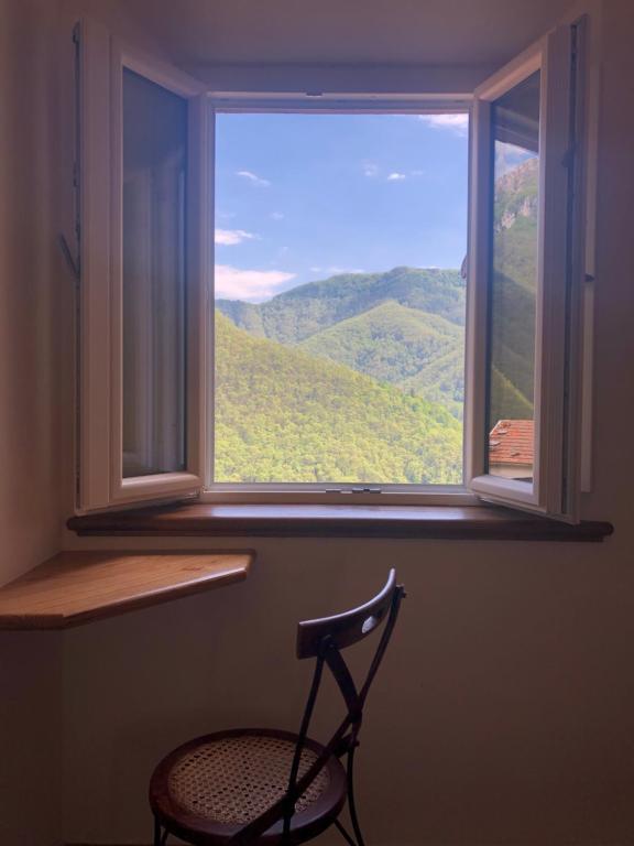 Stazzema的住宿－B&B Convivium，椅子坐在窗户前,享有美景