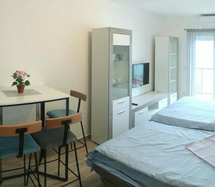 a bedroom with a desk and a bed and a desk with a computer at Apartman Matija in Herceg-Novi