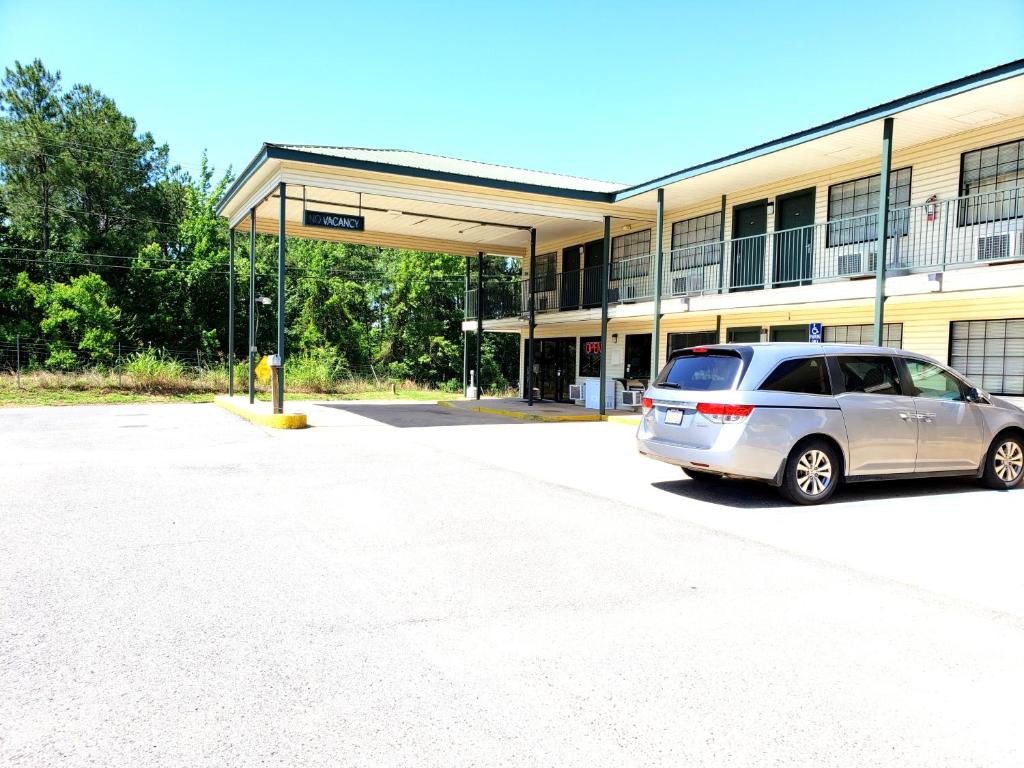 a car parked in a parking lot in front of a building at Motel 103 in Calhoun