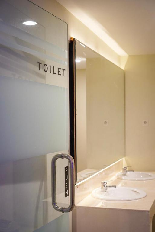 un bagno con due lavandini e un grande specchio di The Capsule Malioboro a Yogyakarta