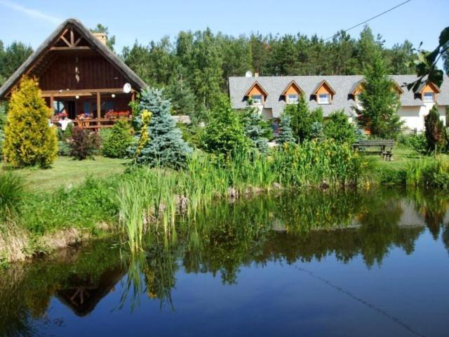 une maison à côté d'un lac en face d'une maison dans l'établissement Koziołkowo, à Bartoszylas