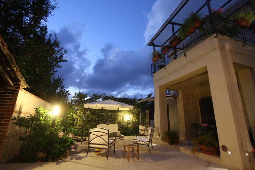 a patio with a table and chairs at night at Turismo Rurale Al Benefizio in Monforte San Giorgio Marina