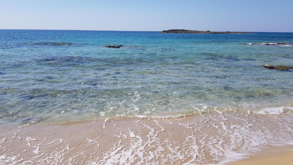 a beach with the ocean and the sand at La Spiaggetta in Torre San Giovanni Ugento