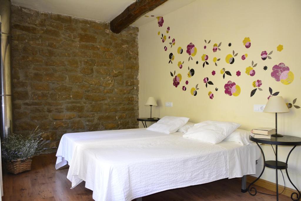 1 dormitorio con 2 camas con flores en la pared en Casa Rural Kandela Etxea, en Lapuebla de Labarca