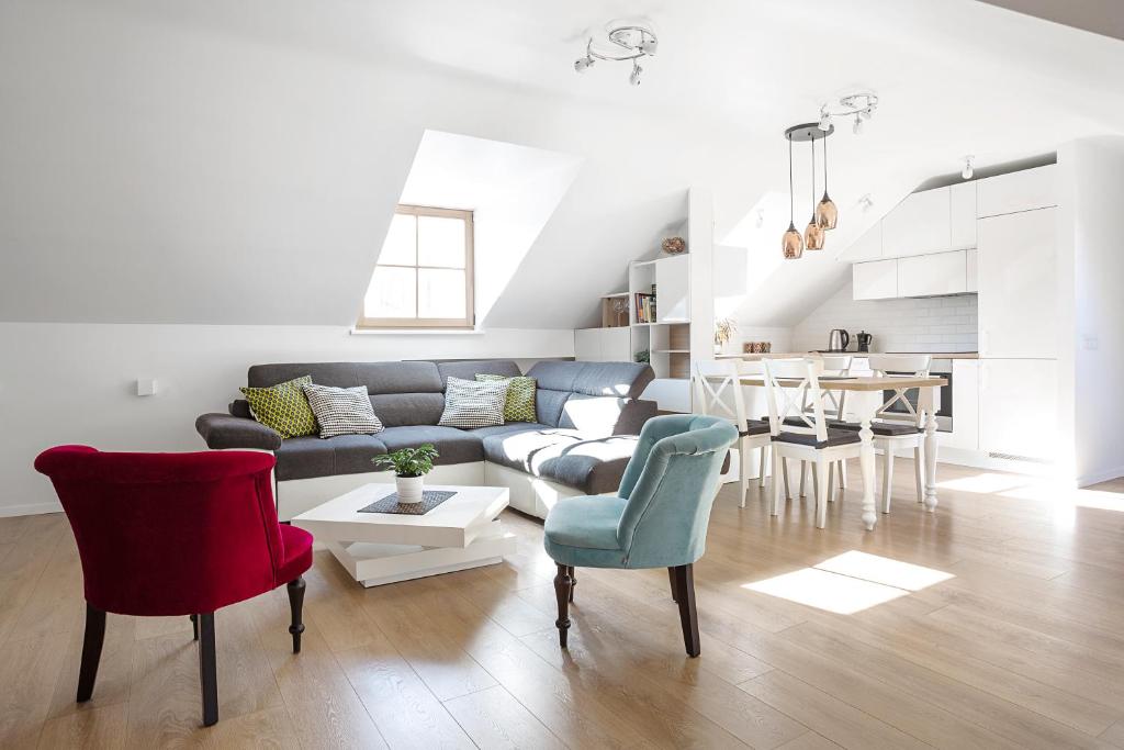 a living room with a couch and chairs and a table at Baron's Arthouse Apartment in Vilnius