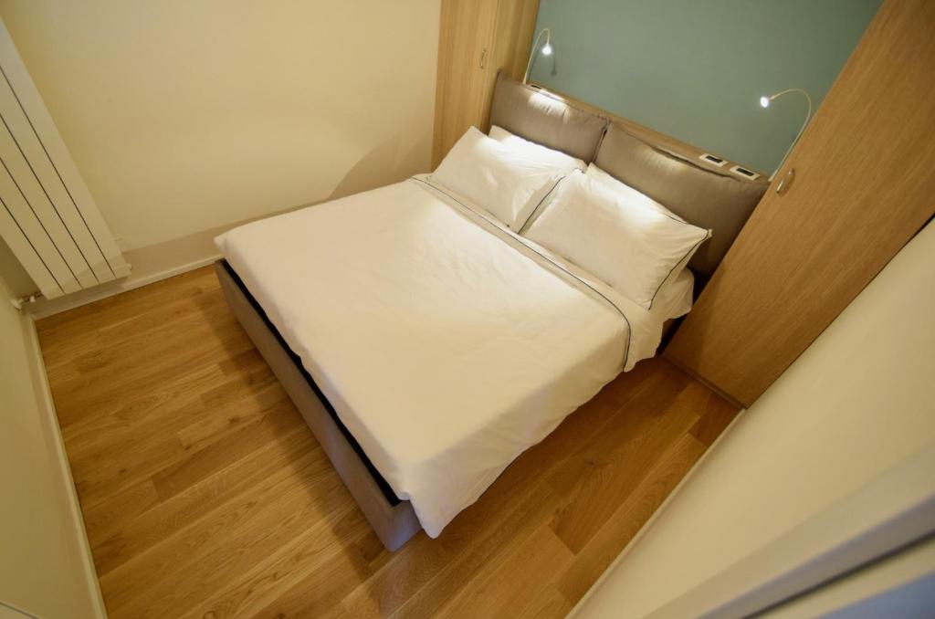 een kleine slaapkamer met een bed met witte lakens en kussens bij Casa Bredina in Iseo