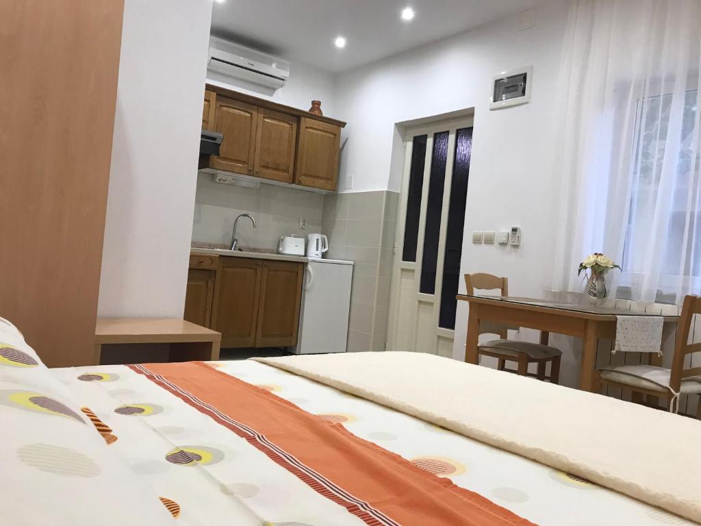 a bedroom with a bed and a table and a kitchen at Apartments Jani in Hvar