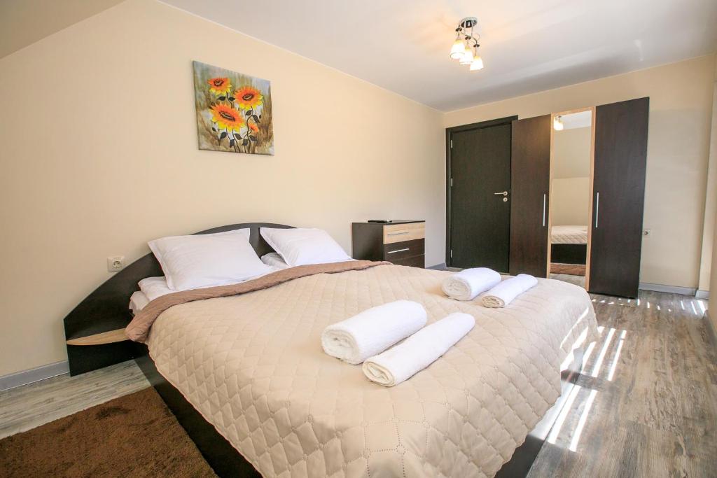 - une chambre avec un grand lit et des oreillers blancs dans l'établissement Sunpark Apartment, à Sandanski