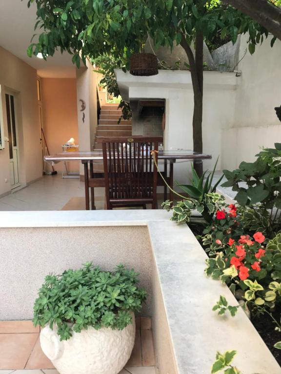 a garden with a table and a tree and flowers at Apartments Jani in Hvar