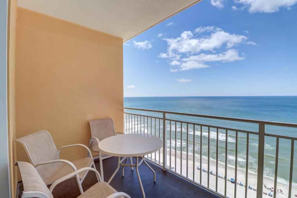 balcón con mesa, sillas y vistas al océano en Sterling Reef, en Panama City Beach