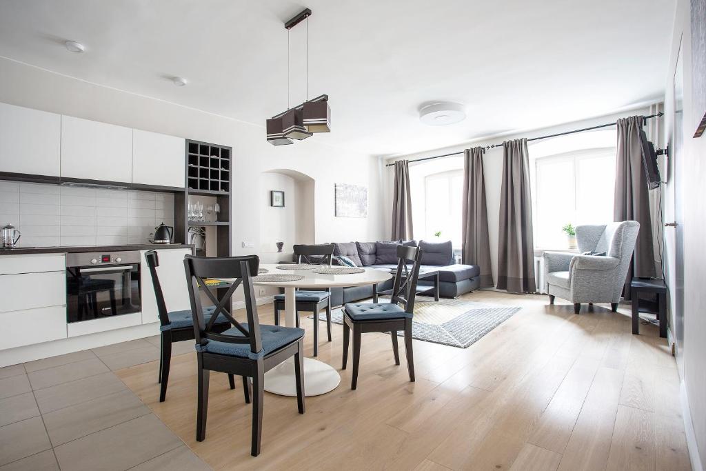 a kitchen and living room with a table and chairs at Baron Old Town Apartments in Vilnius