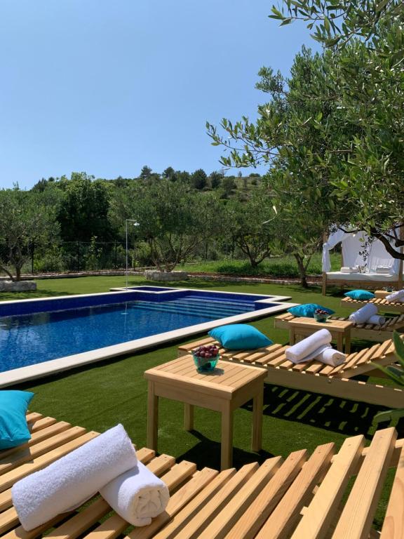 einen Pool mit Liegestühlen, einem Tisch und einem Pool in der Unterkunft Luki Home in Dubrovnik