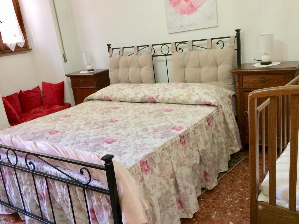 1 Schlafzimmer mit einem Bett mit Blumenbettdecke in der Unterkunft Alloggio Turistico Isonzo - Bracciano (Roma) in Bracciano