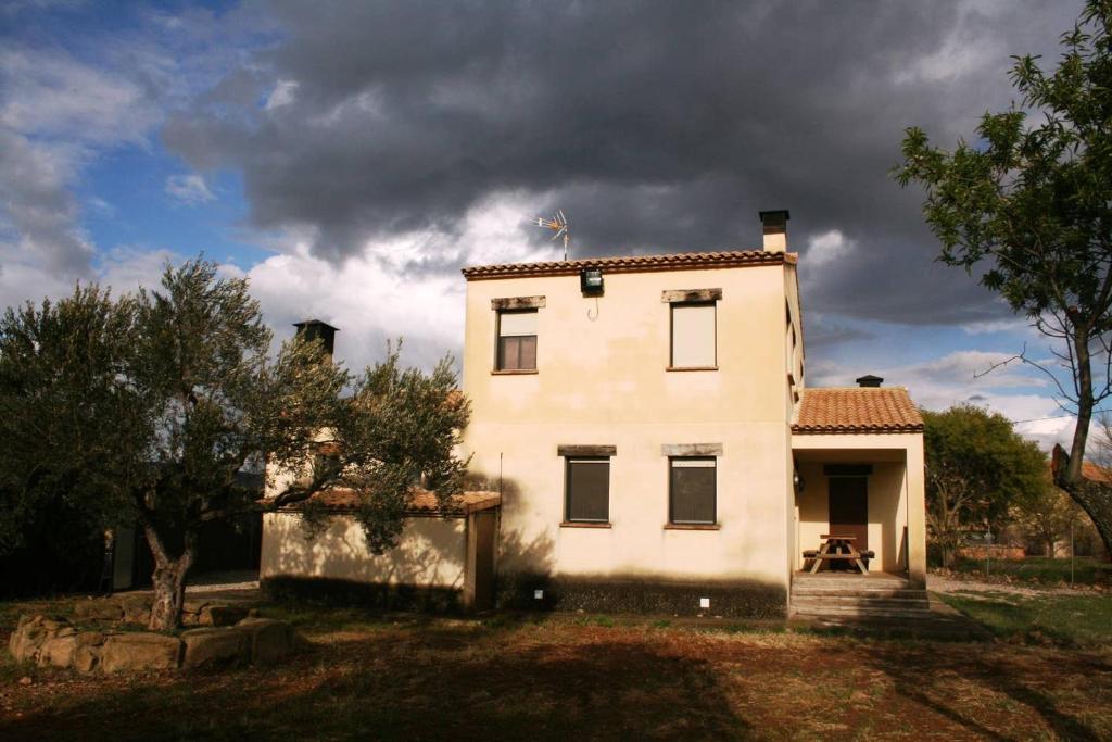 una gran casa blanca con un cielo nublado en La Era en Guara, en Ibieca