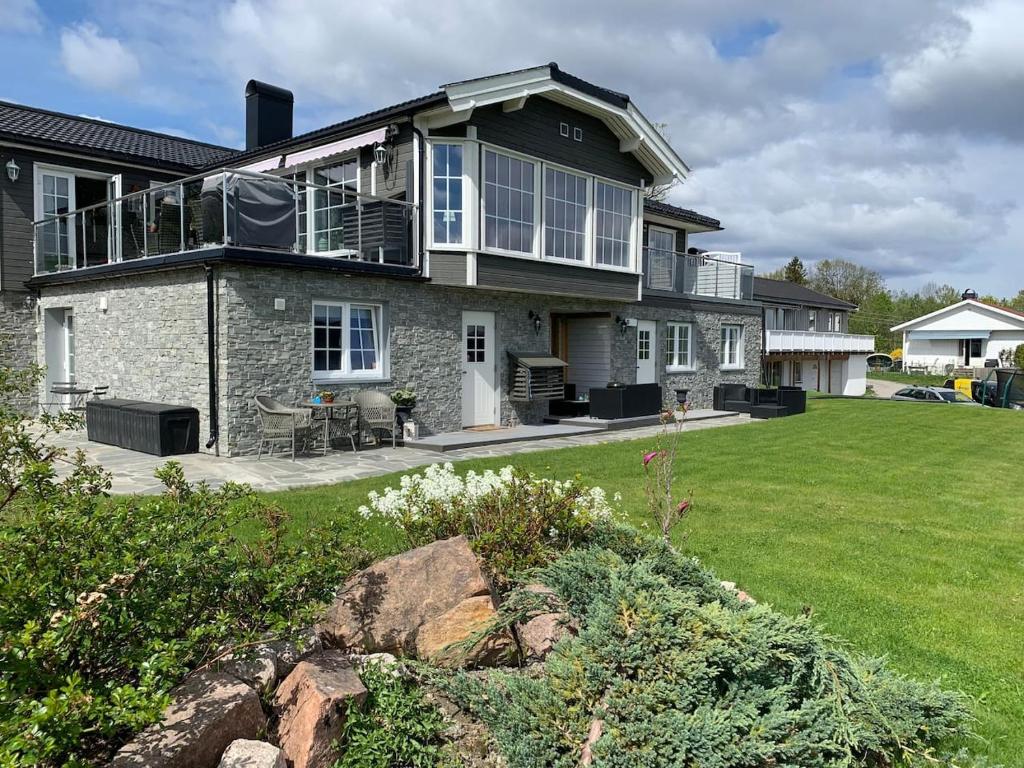 uma grande casa com um grande quintal com um relvado verde em Åskollen, Drammen em Drammen