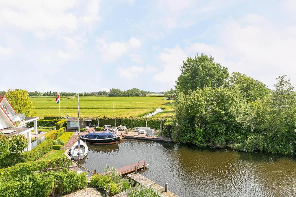 a boat is docked at a dock on a river at Villa Envie in Terherne