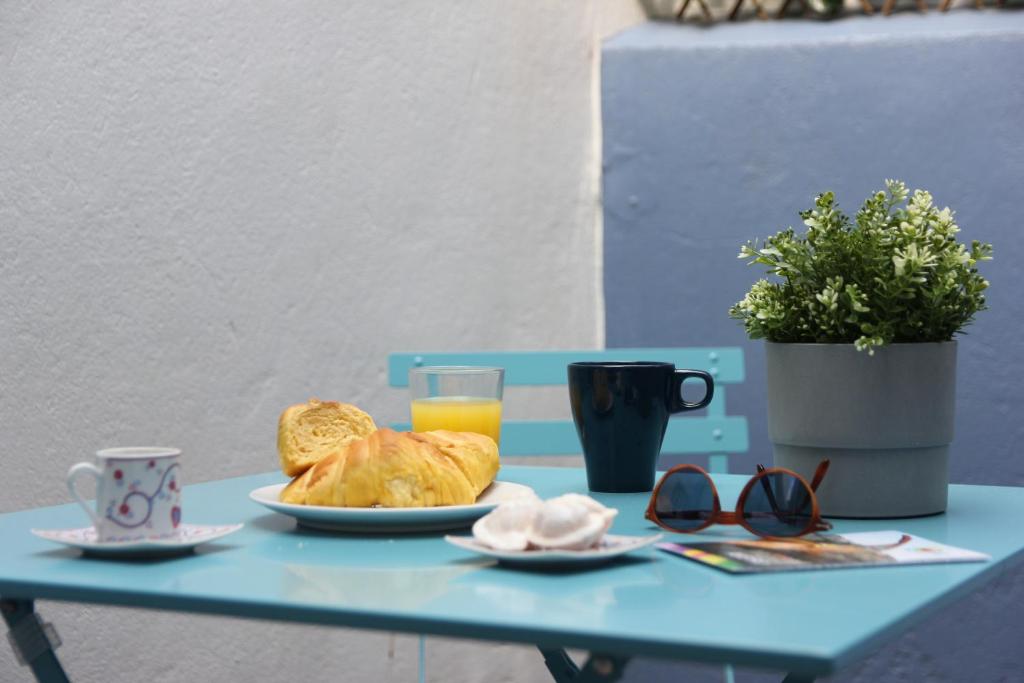 a table with a plate of bread and a glass of orange juice at Aveiro2stay in Aveiro