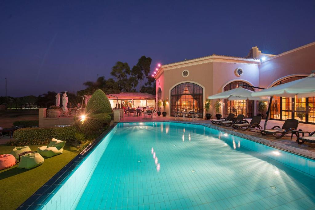 ein Schwimmbad vor einem Gebäude in der Nacht in der Unterkunft Stella Di Mare Golf Hotel in Ain Suchna