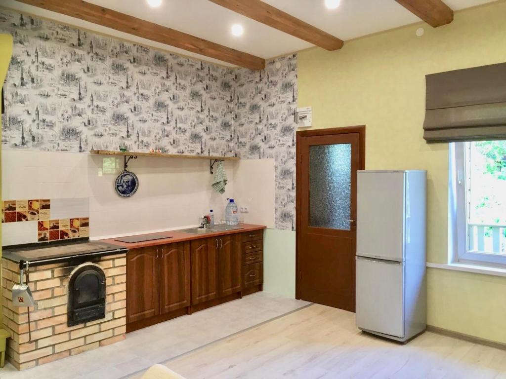 een keuken met een koelkast en een fornuis bij Ligatne's Village Studio Apartment in Līgatne