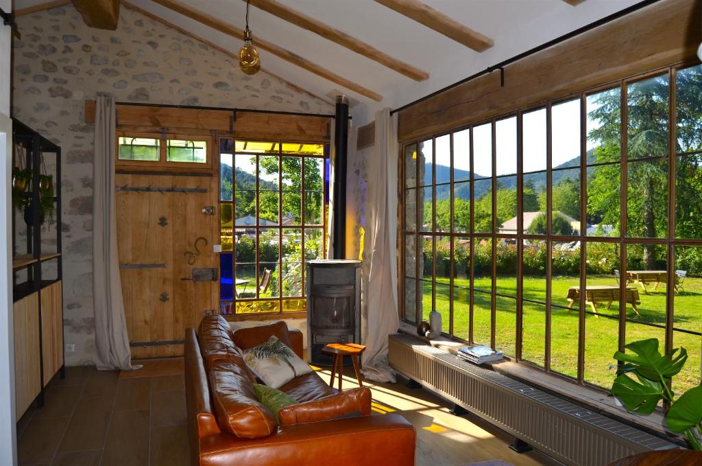 salon z kanapą i dużym oknem w obiekcie Mas Mialou w mieście Saint-Jean-du-Gard