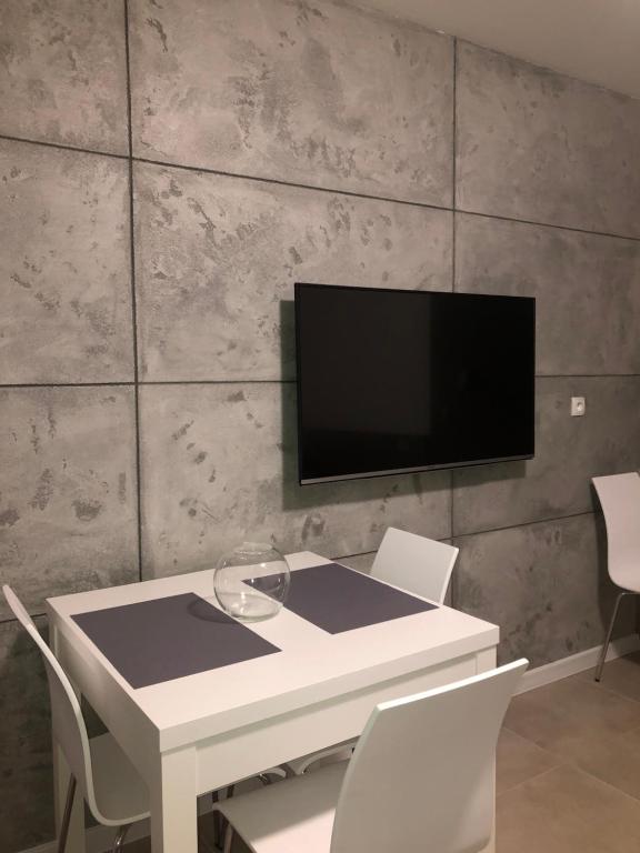 ヤストシェンビャ・グラにあるAmorの白いテーブル(椅子付)、壁掛けテレビ